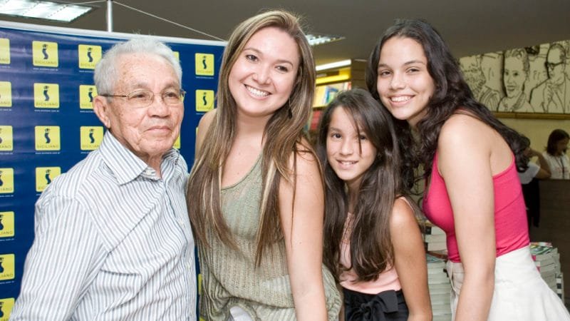 Floriano Bezerra de Araújo é fotografado com suas netas Raissa Ribeiro, Sarah Araújo e Maíra Araújo, filhas de Renan Ribeiro de Araújo, na então Livraria Siciliano do Shopping Mydway Mall, na noite de autógrafos do lançamento do seu livro Minhas Tamataranas: Linhas Amarelas - Memórias, no ano de 2009